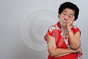 Depressed Asian senior woman lonely disappointed and lose memory in isolated white background. Portrait old woman ill sick