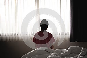 Depressed asian woman has sad and lonely feel sitting on the bed in the morning
