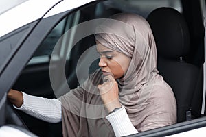 Depressed attractive islamic african american woman driver in hijab driving car, stop and waiting for movement