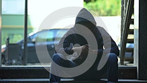 Depressed black boy sitting on stairs contemplating about hard life in ghetto