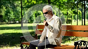 Depressed blind man sitting alone in park, socially disadvantaged population photo