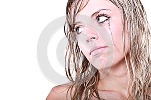 Depressed blond woman with a tear running down