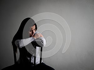 Depressed broken hearted woman sitting alone on a wooden chair