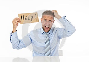 Depressed businessman holding help sign message helpless and desperate with laptop