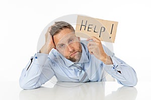 Depressed businessman holding help sign message helpless and desperate with laptop