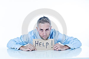 Depressed businessman holding help sign message helpless and desperate with laptop