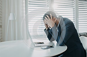 Depressed businessman man counting euro money working on computer at office desk, inflation concept.