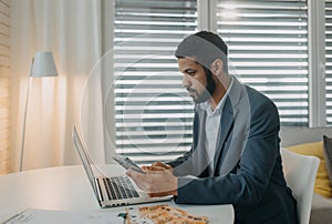 Depressed businessman man counting euro money working on computer at office desk, using smartphone , inflation concept.
