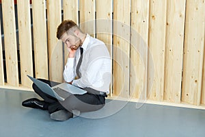 Depressed Businessman sitting on floor at his office. Hard work