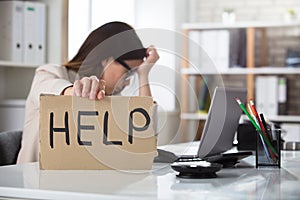 Depressed Businesswoman Holding Help Sign