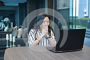 Depressed Casual Business Asian Woman using a laptop in hotel, g