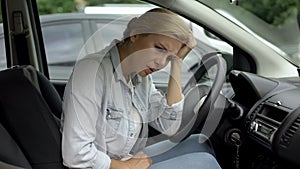 Depressed casual woman sitting in car, dissatisfied with her life, daily routine