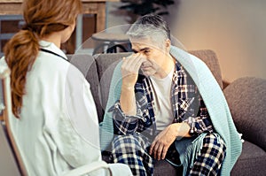 Depressed cheerless man having a conversation with his doctor