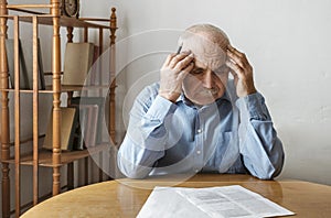 Depressed, concerned senior man doing paperwork