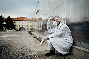 Depressed crying doctor with mask having mental breakdown.Fear,anxiety,panic attack due to coronavirus outbreak.Psychological
