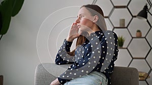 Depressed and dejected woman sitting on the sofa in the house