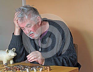 Depressed elderly man counting money. photo