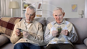 Depressed elderly men counting money, low social payment, poverty problems