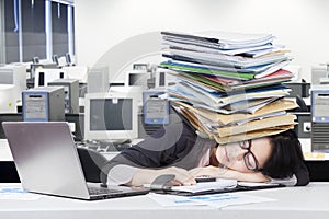 Depressed female worker napping on desk