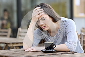 Depressed girl complaining on a coffee shop terrace