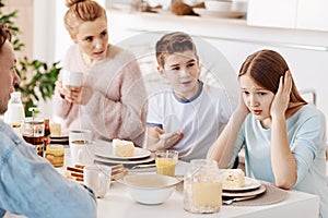 Depressed girl having breakfast with her family