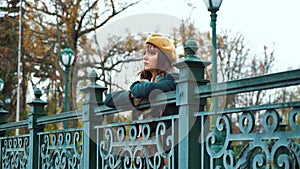 Depressed girl standing on bridge in park