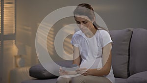 Depressed lady tearing ultrasonographic picture and crying, unwanted pregnancy