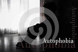 Depressed little boy sitting alone near wall. Autophobia