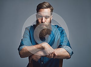 Depressed man with arms on back of chair over gray