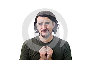 Depressed man keeps palms folded together as pleading or begging for something isolated on white background. Sobbing guy prays for
