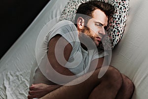 Depressed man in pain on the bed