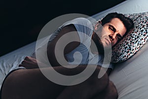 Depressed man in pain on the bed