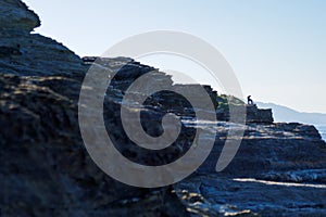 Depressed man sitted thicking on a bench on a cliff. Unhappy alone person