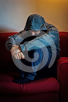 Depressed man sitting alone on a couch