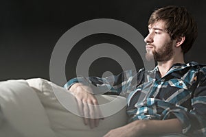 Depressed man is sitting on couch