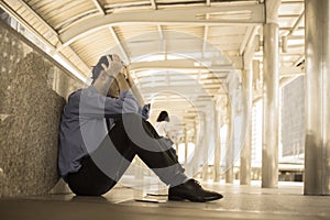 Depressed man sitting on floor head in hands
