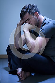 Depressed man sitting on the floor