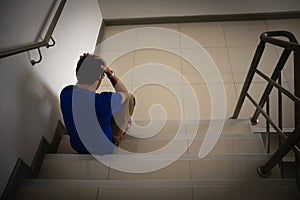 Depressed man sitting on stair of residence building. Sad man, Cry, drama, lonely and unhappy concept