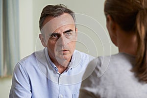 Depressed Mature Man Talking To Counsellor photo