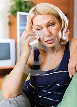 Depressed mature woman on sofa