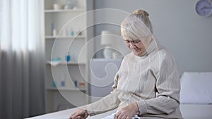 Depressed old lady looking at brain x-ray and crying, incurable disease, health