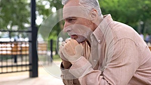 Depressed old male crying on park bench alone, retirement problems, soul pain