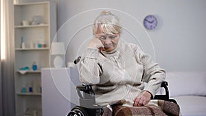 Depressed old woman in wheelchair thinking about health problems at hospital