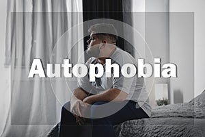 Depressed overweight man sitting alone on bed. Autophobia