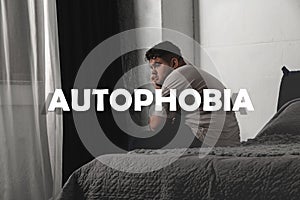 Depressed overweight man sitting alone on bed. Autophobia