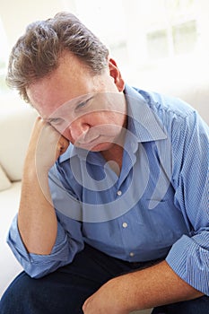 Depressed Overweight Man Sitting On Sofa