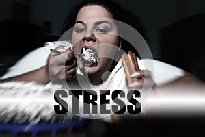 Depressed overweight woman eating sweets and word STRESS