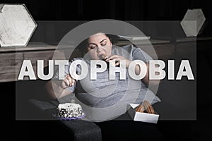 Depressed overweight woman eating sweets on sofa. Autophobia