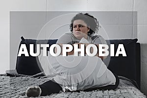 Depressed overweight woman sitting alone on bed. Autophobia