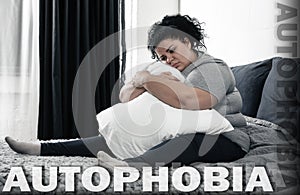 Depressed overweight woman sitting alone on bed. Autophobia